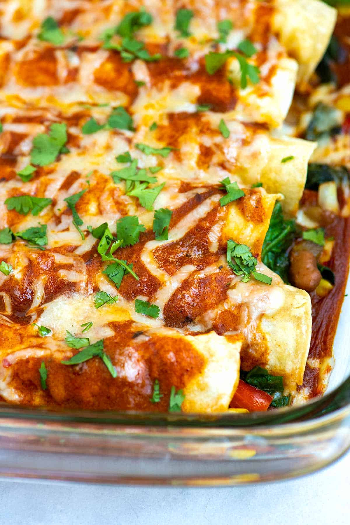 Vegetable and Bean Enchiladas lined up in a baking dish